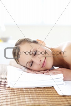 Glowing young woman lying on a massage table 