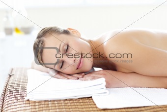 Glad young woman lying on a massage table 