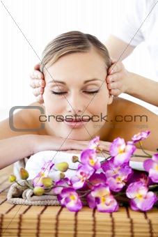 Portrait of a positive young woman receiving a head massage 