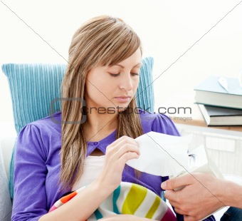 Sick woman with tissue lying on a couch