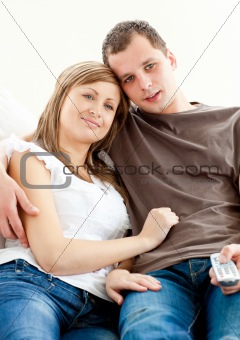 Portrait of a hugging couple watching television 
