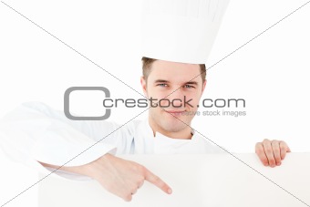 Self-assured caucasian male cook holding a placard showing on it