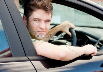 Happy young male driver sitting in his car
