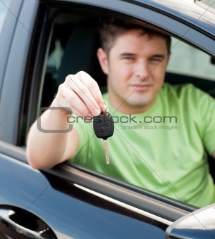 Happy young male driver sitting in blue car
