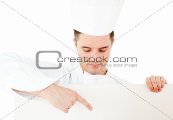 Young caucasian cook showing on a white placard