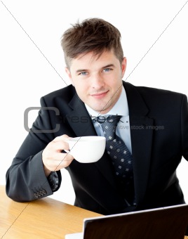 Charming young businessman holding a cup smiling at the camera 