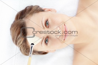 Portrait of a smiling woman having a spa treatment in a health center with a brush