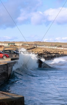 waves crashing against seaside wall
