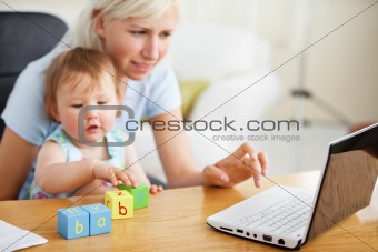 Positive family using laptop and playing with toys 