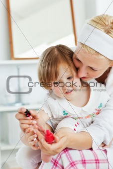 Charming mother making her little daughter's nails
