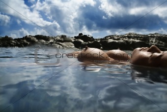 Nude woman floating in sea.
