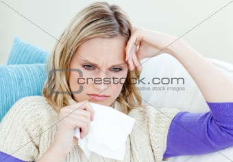 Diseased woman lying on a sofa with tissues