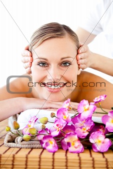 Pretty woman with flowers enjoying a head massage