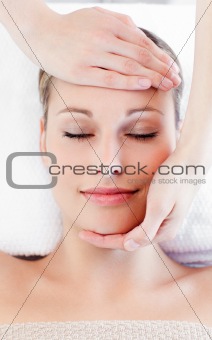Young charming woman receiving a head massage