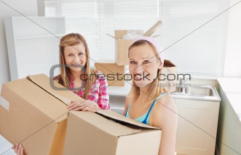 Bright female friends holding boxes 