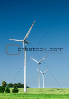 three wind turbines on green field