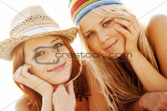 Two beautiful young girlfriends in bikini on the beach