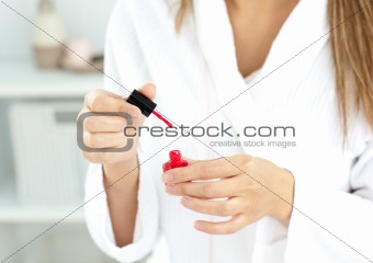 Close-up of a caucasian woman varnishing her fingernails in the 