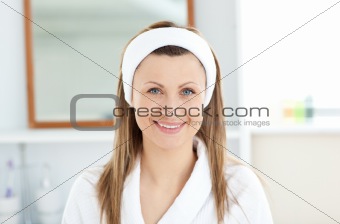 Charming young woman smiling at the camera in the bathroom