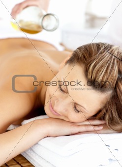 Radiant young woman having a back massage with oil 