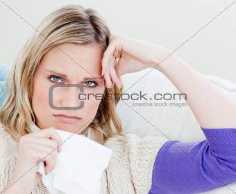 Unhappy sick woman holding tissues looking at the camera 