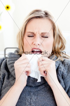 Diseased woman sneezing holding a tissue 