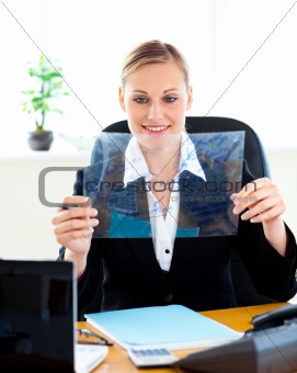smiling female executive looking at a blueprint sitting in her office
