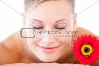 Close-up of a smiling woman lying on a massage table with a flow