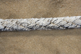 aged marine rope over beach sand background