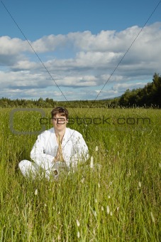 Young man meditates in a field