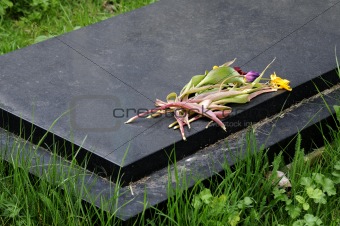 Dead flowers on tombstone