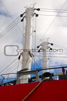 Masts of a red old freighter with pulleys