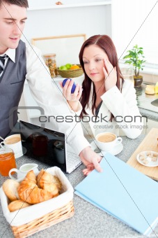 Couple of businesspeople having breakfast in the kitchen
