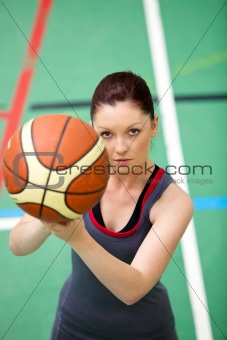 Portrait of a concentrated young woman playing basket-ball