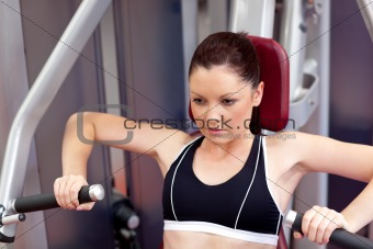 Concentrated athletic woman using a bench press