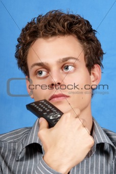 Pondering young man with remote control