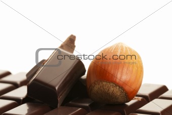 hazelnut and chocolate pieces on a plain chocolate bar