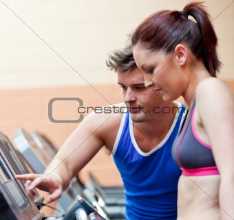 Pretty athletic woman standing on a running machine with her per
