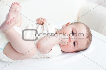 Adorable baby lying on the back in the living-room