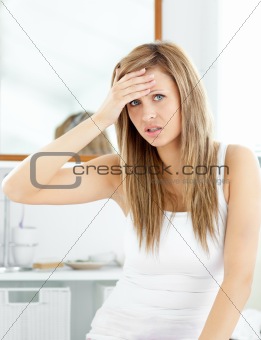 Attractive woman having a headache in the bathroom