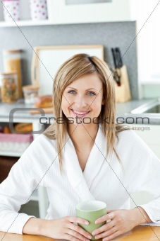 Charming woman drinking coffee in the kitchen