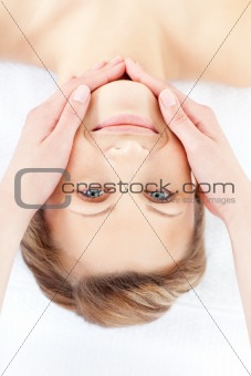 Positive woman receiving a facial massage smiling at the camera 