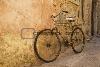 Old bicycle at a wall