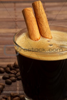 cinnamon sticks inside espresso in a short glass