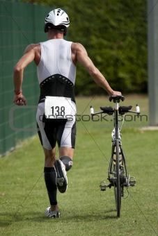 Triathlete pushing his bike