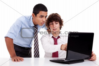 Two young businessmen working together on a laptop, isolated on white, studio shot