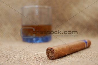 Cuban cigar and glass with wiskey on sackcloth