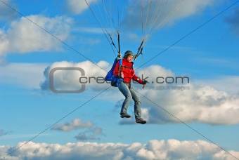 The young girl parachutist in cloudy sky