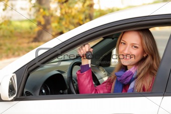 The happy woman showing the key of her new car