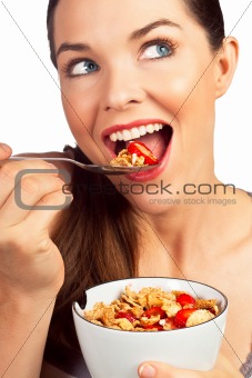Beautiful young woman eating a healthy bowl of cereal with straw